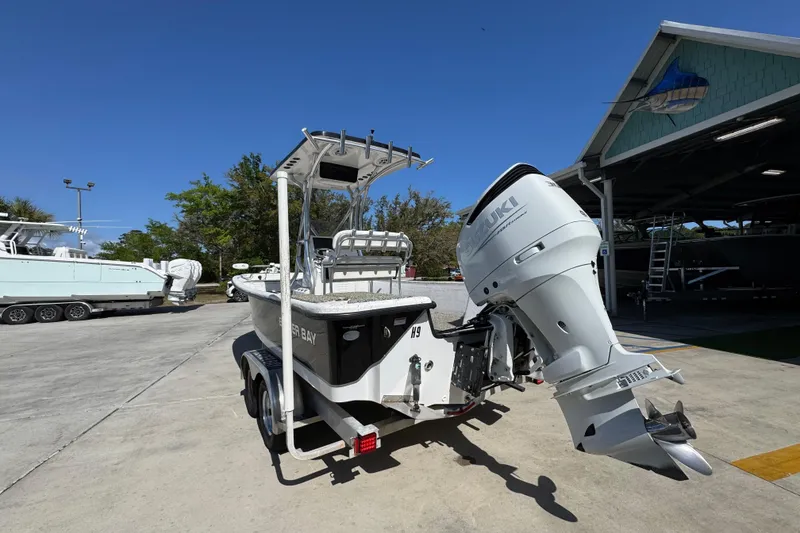 Slide: The Image of 2021 Blazer Bay 2400 boat with Suzuki outboard motor on trailer, parked outdoors. - 16