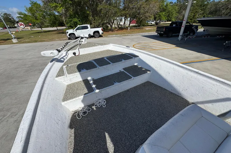 Slide: The Image of 2021 Blazer Bay 2400 boat interior with seating and storage compartments in a parking area. - 20