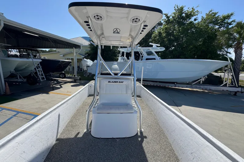 Slide: The Image of 2021 Blazer Bay 2400 boat on display at a marina with other vessels. - 25