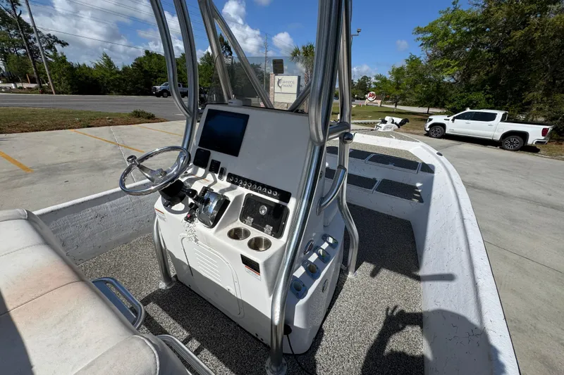 Slide: The Image of 2021 Blazer Bay 2400 boat console with steering wheel and controls, parked outdoors. - 33