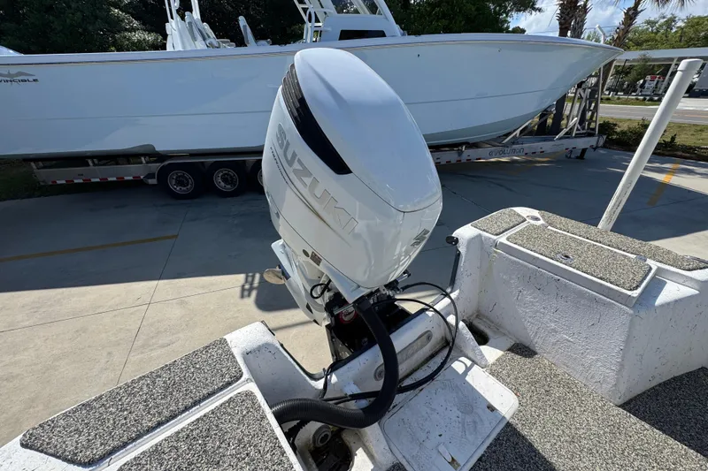 Slide: The Image of 2021 Blazer Bay 2400 boat with Suzuki outboard motor in a parking area. - 38