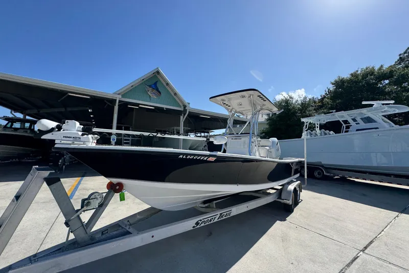 Slide: The Image of 2021 Blazer Bay 2400 boat on trailer under clear blue sky at marina. - 4
