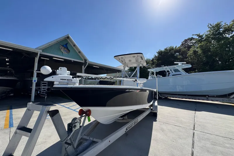 Slide: The Image of 2021 Blazer Bay 2400 boat on trailer, parked outdoors under clear blue sky. - 5