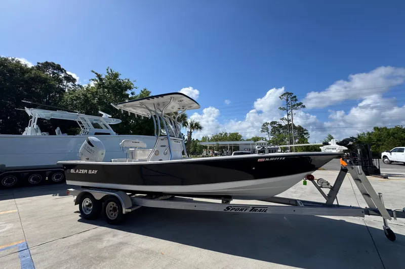 Slide: The Image of 2021 Blazer Bay 2400 boat on trailer under clear blue sky. - 9
