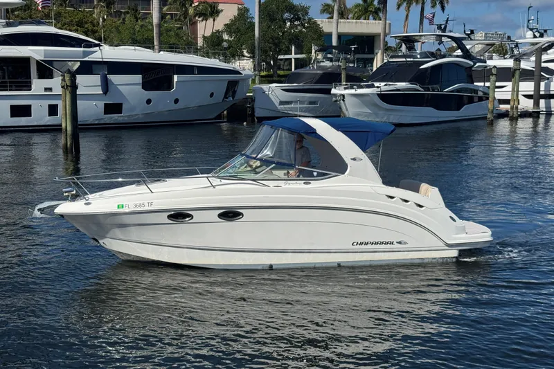 The Image of 2009 Chaparral Signature 250 boat cruising in a marina with yachts in the background. - 0