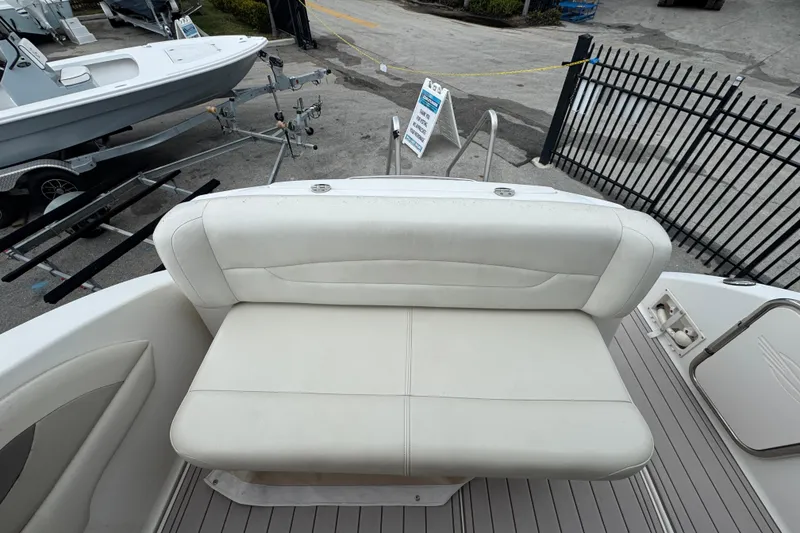 Slide: The Image of 2009 Chaparral Signature 250 boat with white cushioned seating and dock view. - 11