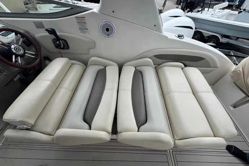 Slide: The Image of 2009 Chaparral Signature 250 boat interior with white cushioned seating and steering wheel. - 16