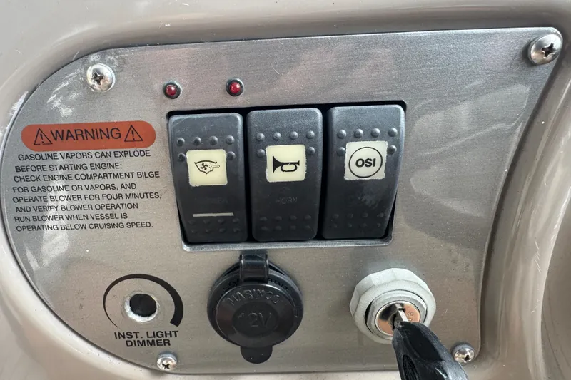 Slide: The Image of Control panel of a 2009 Chaparral Signature 250 boat with warning label and switches. - 19