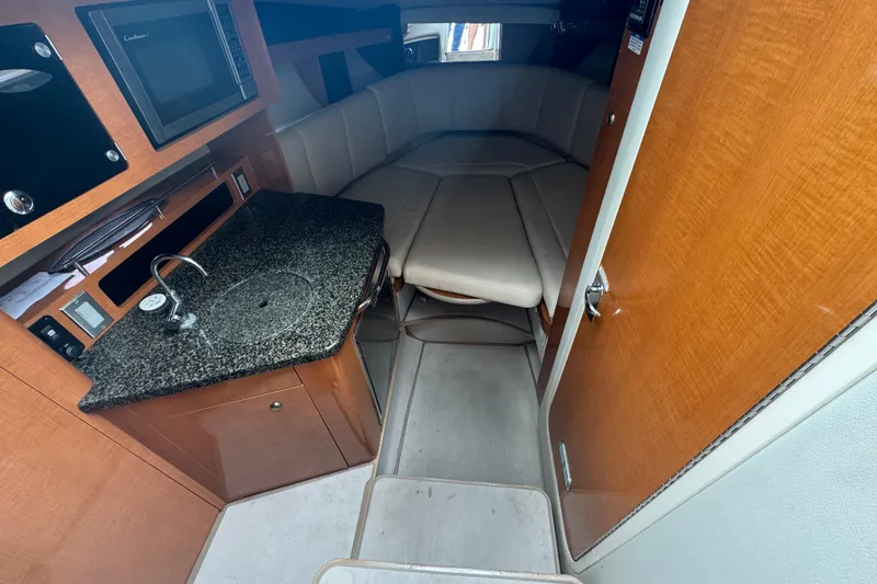 Slide: The Image of 2009 Chaparral Signature 250 cabin interior with kitchenette and seating area. - 33