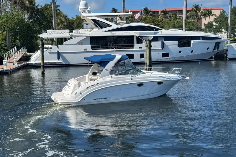 Slide: The Image of 2009 Chaparral Signature 250 boat cruising in a marina with blue canopy. - 4
