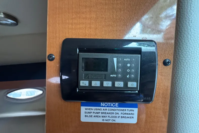 Slide: The Image of Control panel on a 2009 Chaparral Signature 250 boat with air conditioner notice. - 42