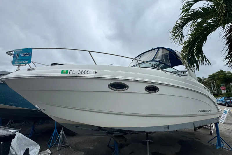 Slide: The Image of 2009 Chaparral Signature 250 boat on display, featuring sleek white design and blue canopy. - 6