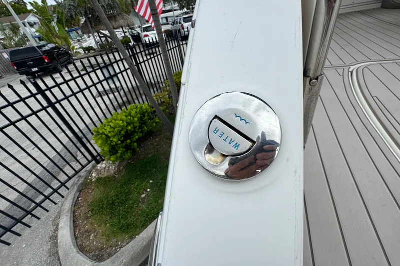 Slide: The Image of 2009 Chaparral Signature 250 boat water fill cap with reflection, docked near a fence. - 8