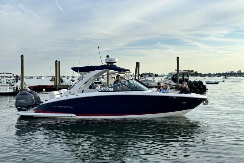 The Image of 2017 Regal 29 OBX boat on water with passengers, docked in a marina. - 0