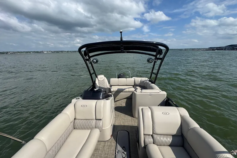 Slide: The Image of 2019 Harris Solstice 220 pontoon boat on a lake under a partly cloudy sky. - 12