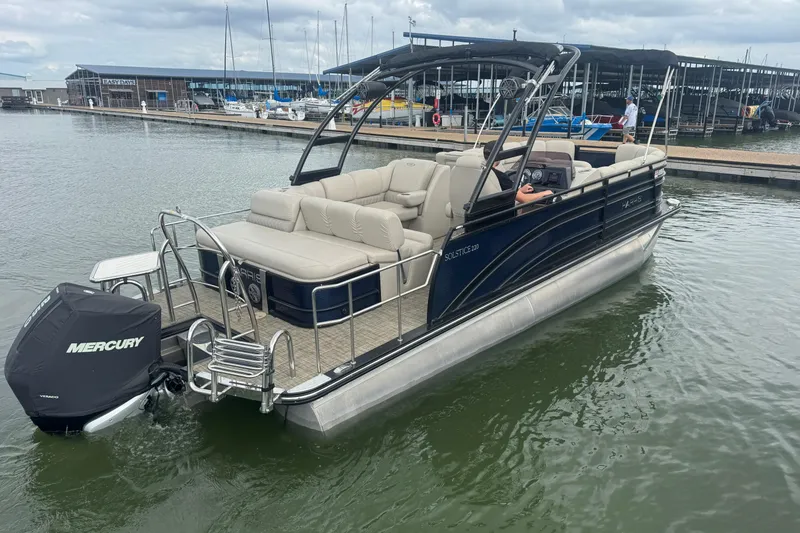 Slide: The Image of 2019 Harris Solstice 220 pontoon boat with Mercury engine docked at marina. - 7