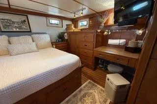 Slide: The Image of 1982 Kong & Halvorsen Island Gypsy yacht cabin with cozy bed, wooden furniture, and decor. - 27