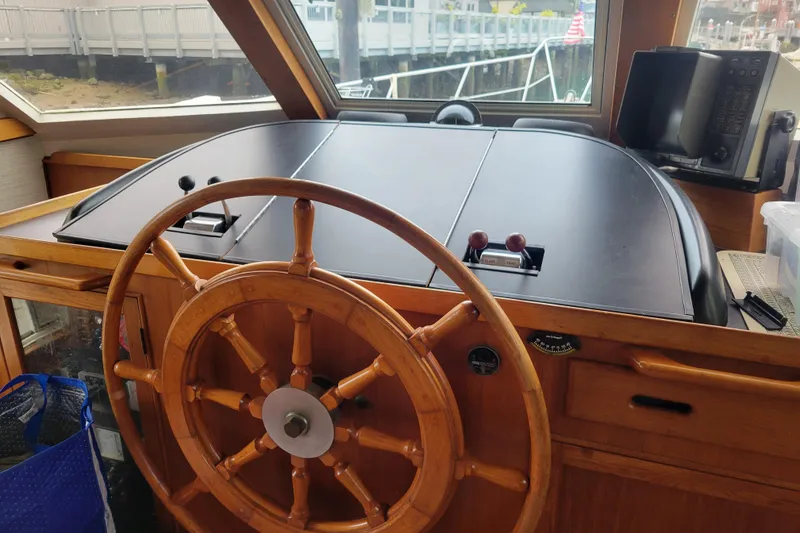 Slide: The Image of Wooden helm of a 1982 Kong & Halvorsen Island Gypsy boat, featuring classic nautical controls. - 35