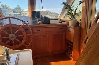Slide: The Image of 1982 Kong & Halvorsen Island Gypsy boat interior with wooden helm and potted plant. - 36
