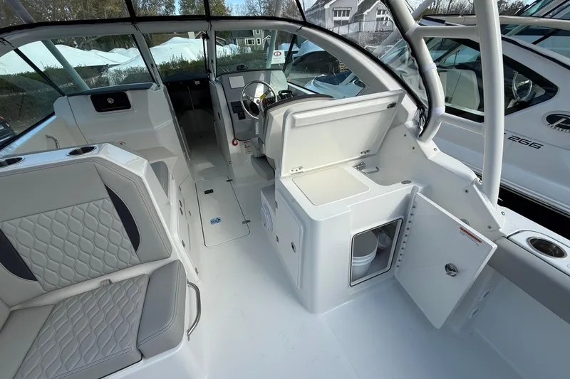 Slide: The Image of 2026 Pursuit DC 266 Dual Console boat interior with seating and storage compartments. - 10