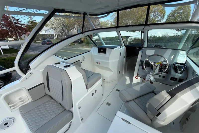 Slide: The Image of 2026 Pursuit DC 266 Dual Console boat interior with modern seating and steering wheel. - 11