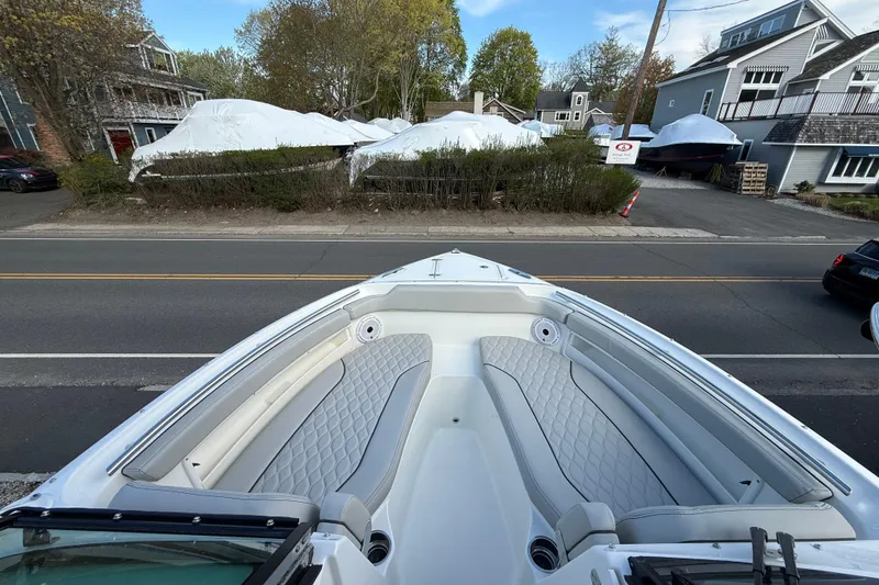 Slide: The Image of 2026 Pursuit DC 266 Dual Console boat with spacious seating, parked near residential area. - 12