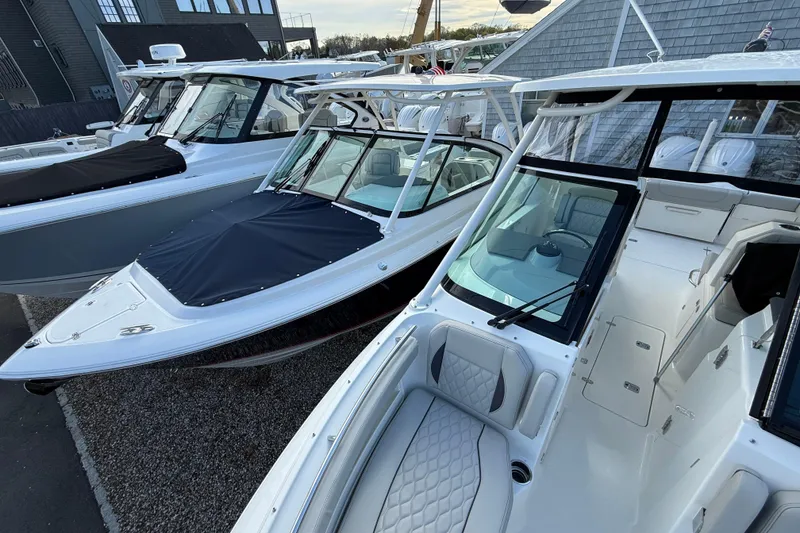 Slide: The Image of 2026 Pursuit DC 266 Dual Console boats displayed at a marina. - 15