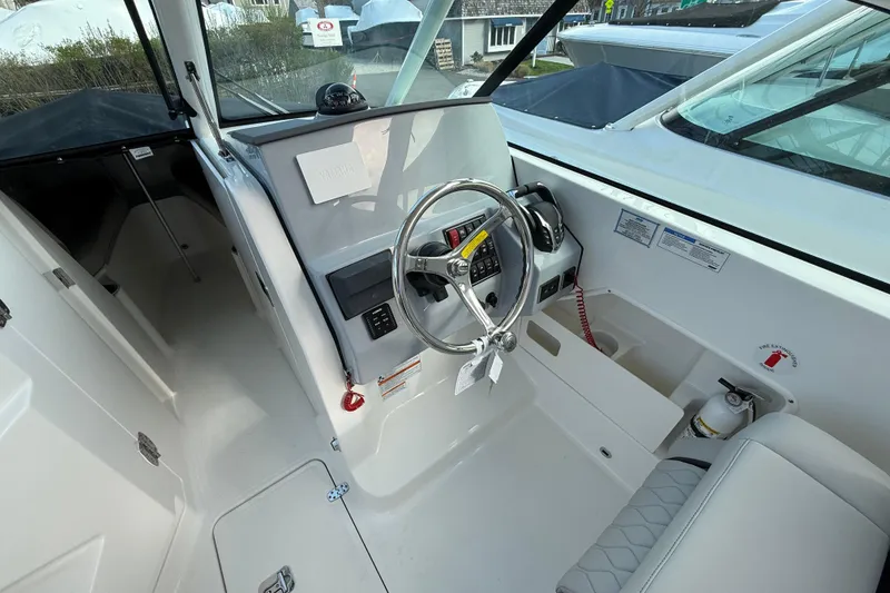 Slide: The Image of 2026 Pursuit DC 266 Dual Console boat cockpit with steering wheel and control panel. - 9