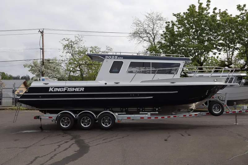 The Image of 2026 KingFisher 3025 XRS boat on trailer, parked outdoors with trees in background. - 1