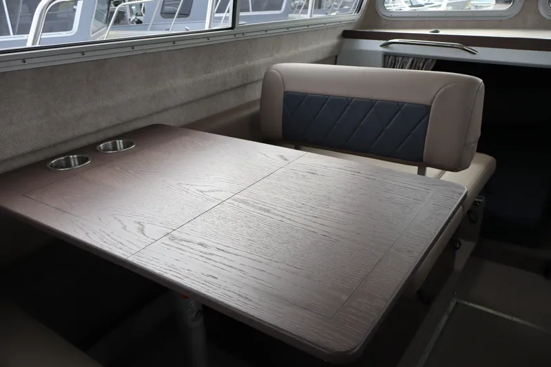 Slide: The Image of Interior of 2026 KingFisher 3025 XRS boat with wooden table and cushioned seating. - 11