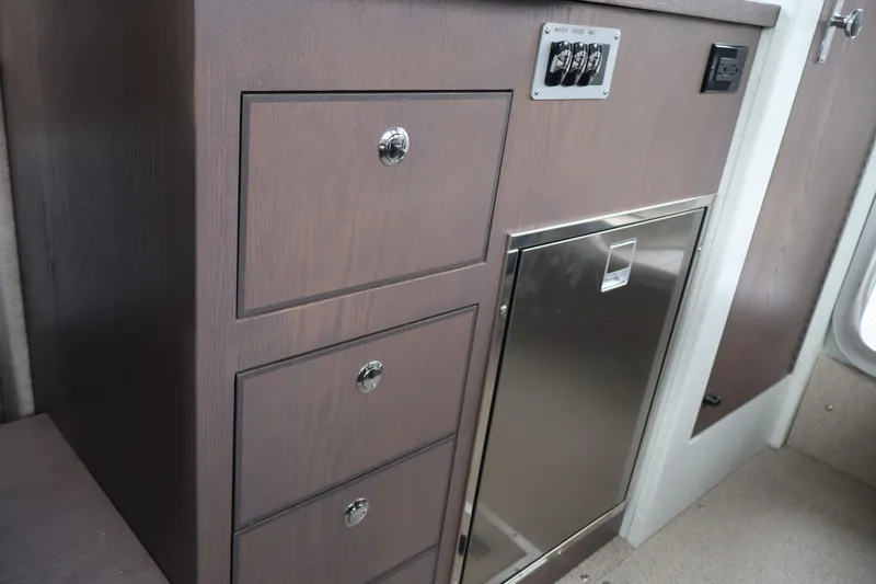 Slide: The Image of Interior of 2026 KingFisher 3025 XRS boat with wooden cabinetry and stainless steel panel. - 17