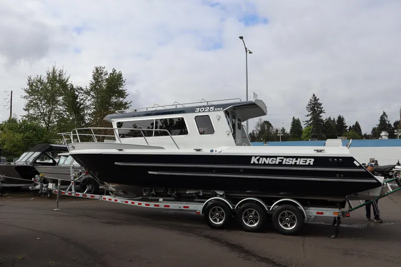 Slide: The Image of 2026 KingFisher 3025 XRS boat on trailer, parked outdoors under cloudy sky. - 3