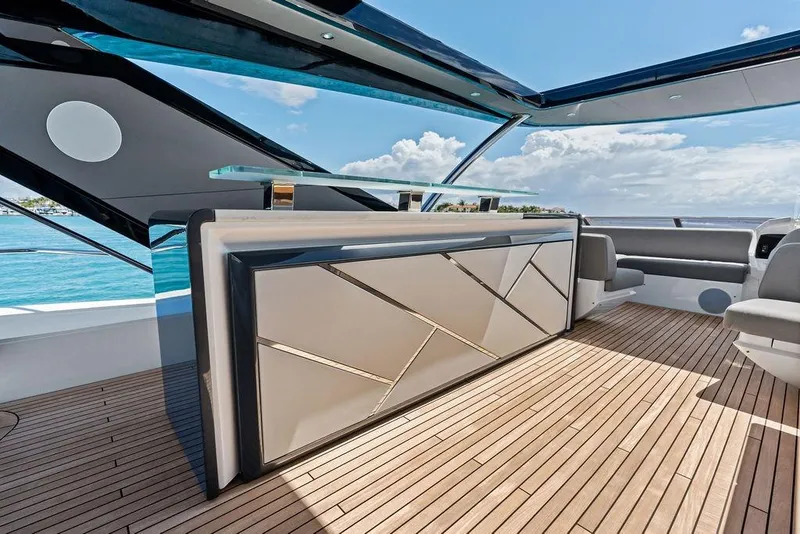 Slide: The Image of Luxurious Sunseeker 88 Yacht 2026 deck with modern bar and seating, overlooking ocean. - 23