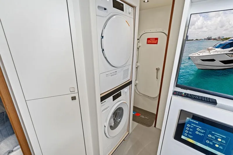 Slide: The Image of Laundry area inside 2026 Sunseeker 88 Yacht with washer, dryer, and control panel. - 98