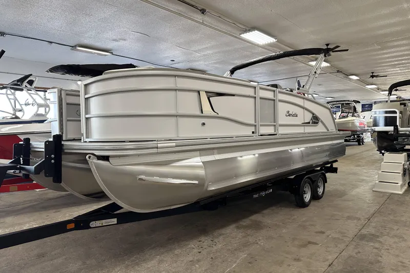 The Image of 2026 Barletta Lusso pontoon boat on trailer in indoor showroom. - 2