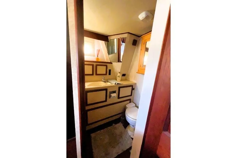 Slide: The Image of Small bathroom interior of 1980 Viking 43 Convertible yacht, featuring sink and toilet. - 13