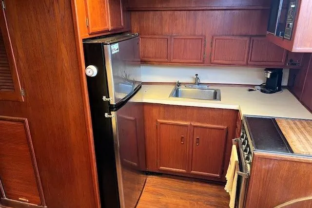 Slide: The Image of 1980 Viking 43 Convertible yacht kitchen with wood cabinetry, stainless steel appliances, and compact design. - 15