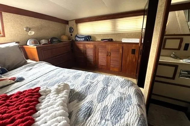 Slide: The Image of Cozy bedroom interior of 1980 Viking 43 Convertible yacht with wood cabinetry and nautical decor. - 18