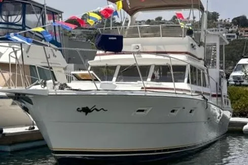 Slide: The Image of 1980 Viking 43 Convertible yacht docked, adorned with colorful flags. - 2