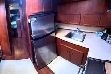 Slide: The Image of 1980 Viking 43 Convertible yacht kitchen with stainless steel fridge and wooden cabinetry. - 25