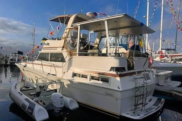 Slide: The Image of 1980 Viking 43 Convertible yacht docked, featuring a spacious deck and inflatable dinghy. - 3