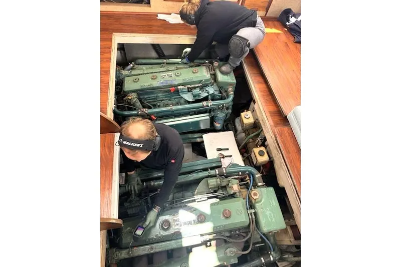 Slide: The Image of Two people working on the engine of a 1980 Viking 43 Convertible boat. - 31