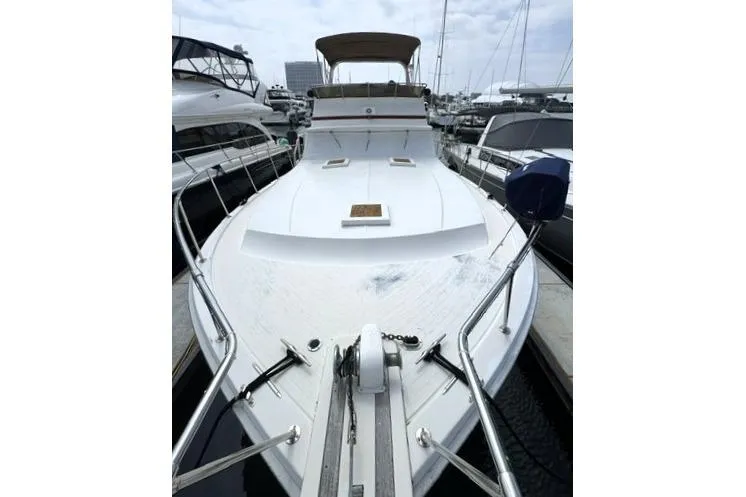 Slide: The Image of 1980 Viking 43 Convertible yacht docked at marina, showcasing spacious deck and sleek design. - 32