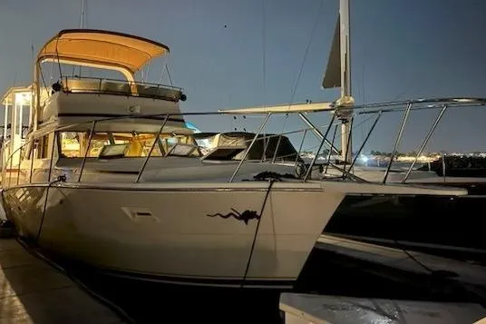 Slide: The Image of 1980 Viking 43 Convertible yacht docked at night, illuminated by soft lighting. - 4
