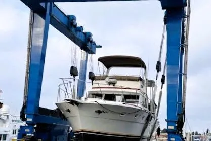 Slide: The Image of 1980 Viking 43 Convertible yacht on a blue boat lift at a marina. - 9