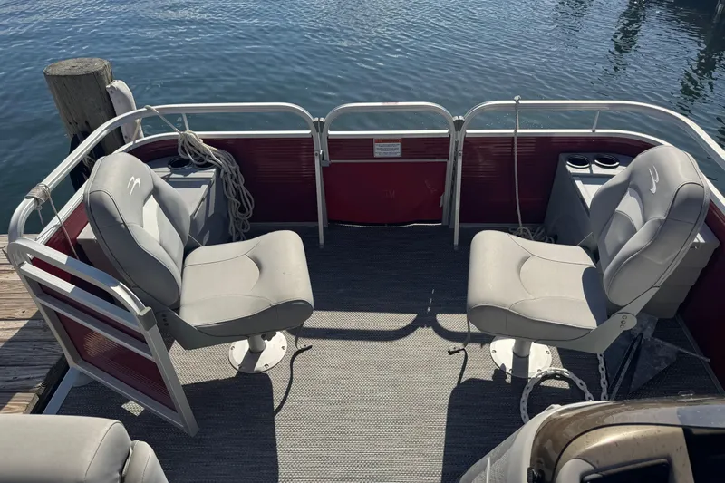 Slide: The Image of 2023 Bennington 188 SVF pontoon boat interior with gray seats and red paneling. - 10