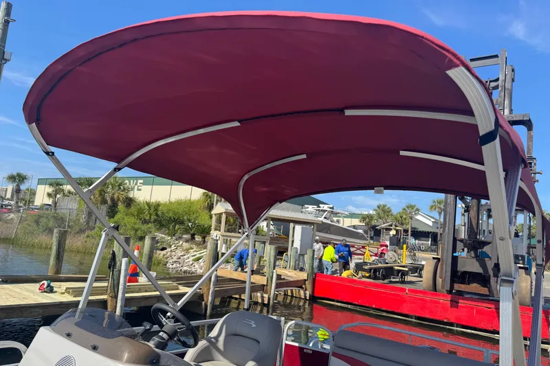 Slide: The Image of 2023 Bennington 188 SVF pontoon boat with red canopy docked at marina. - 15