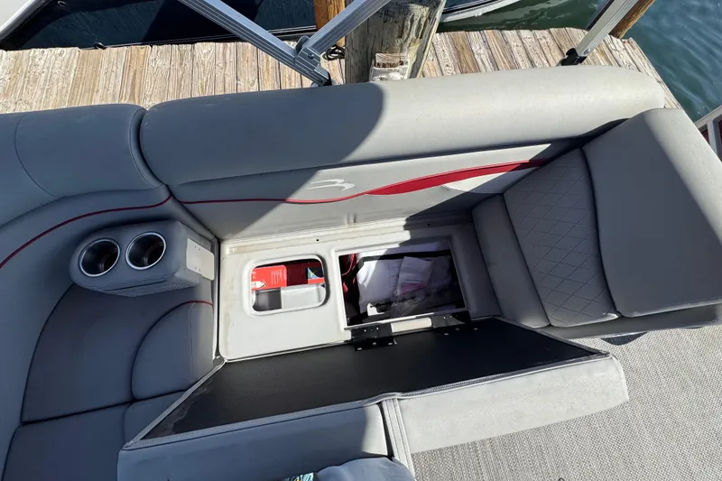 Slide: The Image of 2023 Bennington 188 SVF boat interior with open storage compartment and cup holders. - 4