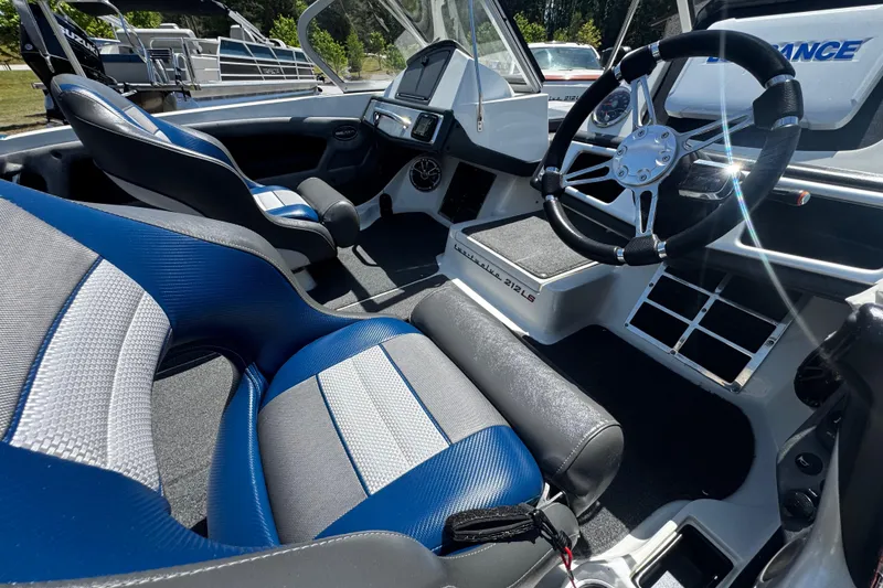 Slide: The Image of 2018 Ranger 212LS Reata boat interior with blue and gray seating, steering wheel, and dashboard. - 11