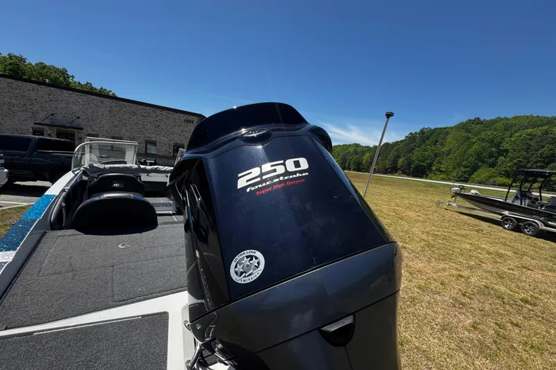 Slide: The Image of 2018 Ranger 212LS Reata boat with 250 horsepower engine, parked outdoors on grass. - 15